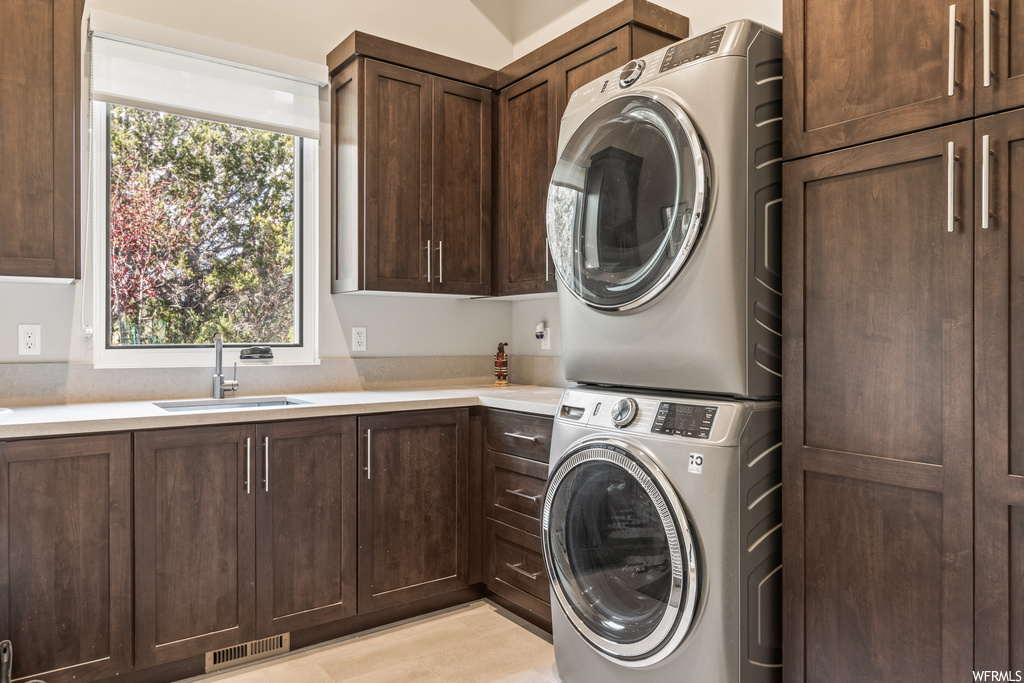 Washroom featuring stacked washer and clothes dryer and light hardwood floors