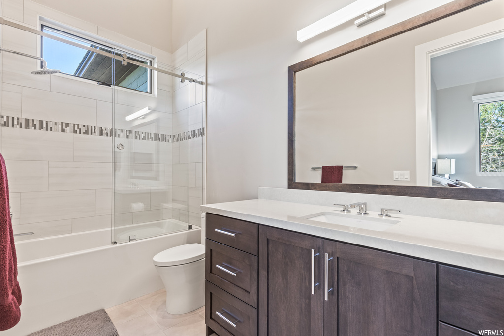 Full bathroom featuring tiled shower / bath combo, oversized vanity, mirror, and light tile floors