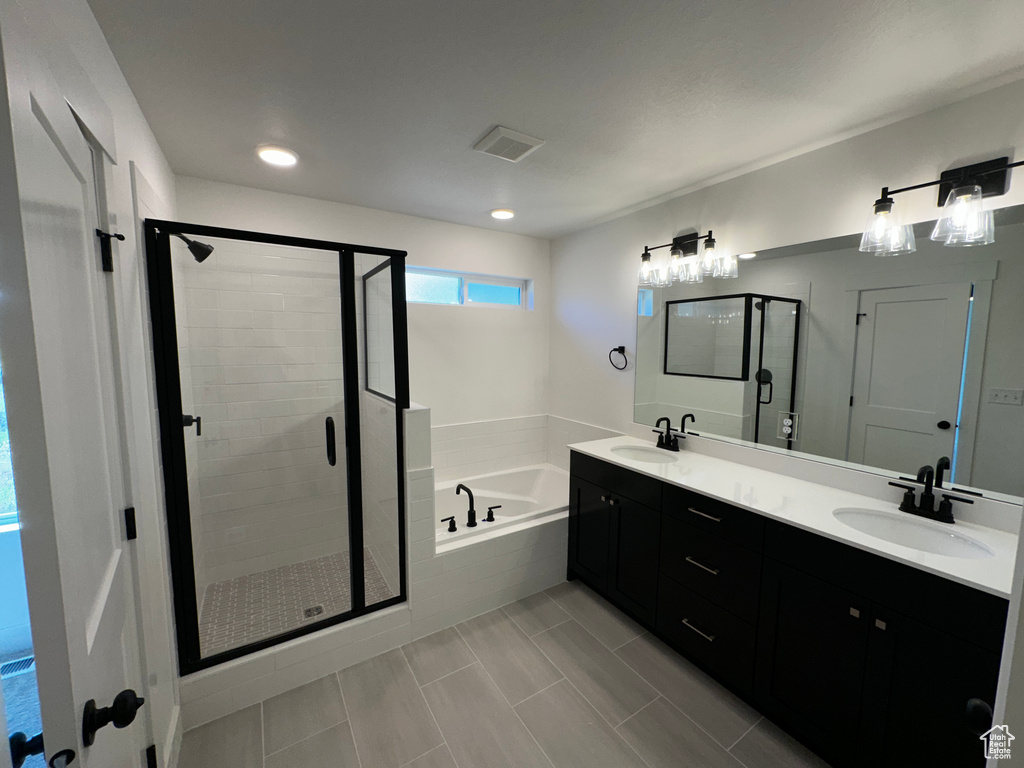 Bathroom with double sink, tile floors, oversized vanity, and separate shower and tub