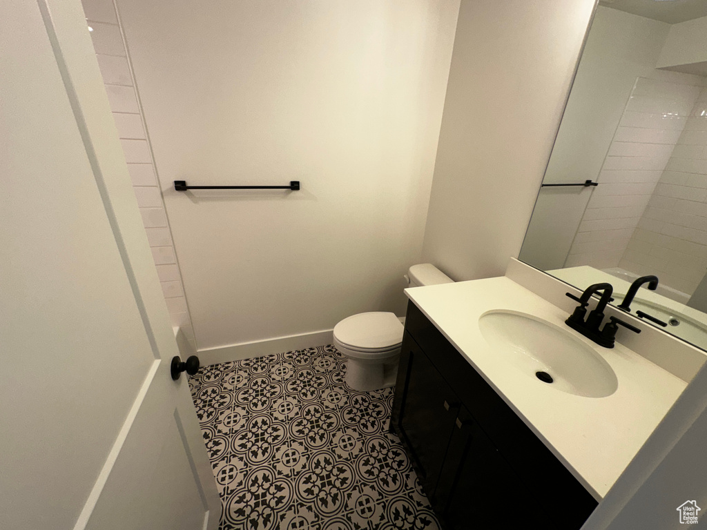 Bathroom with tile flooring, oversized vanity, and toilet