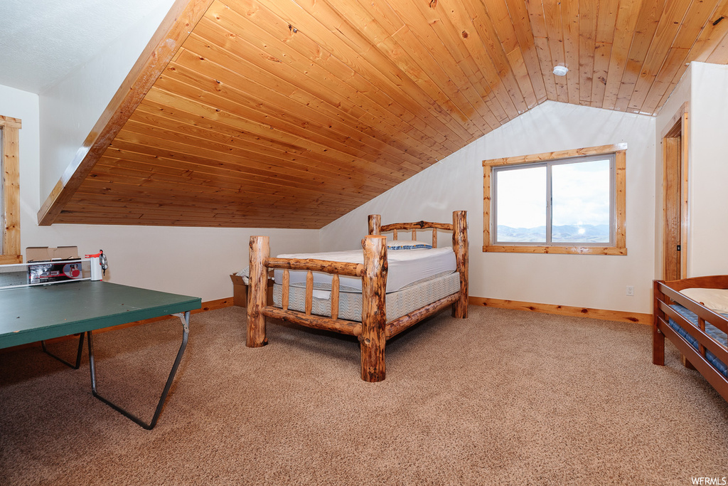 Carpeted bedroom featuring lofted ceiling and wooden ceiling