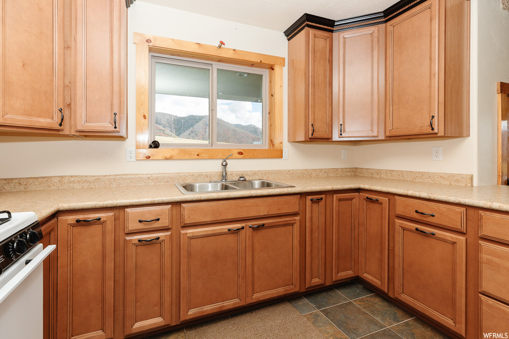 Kitchen featuring a mountain view, white stove, sink, and dark tile floors