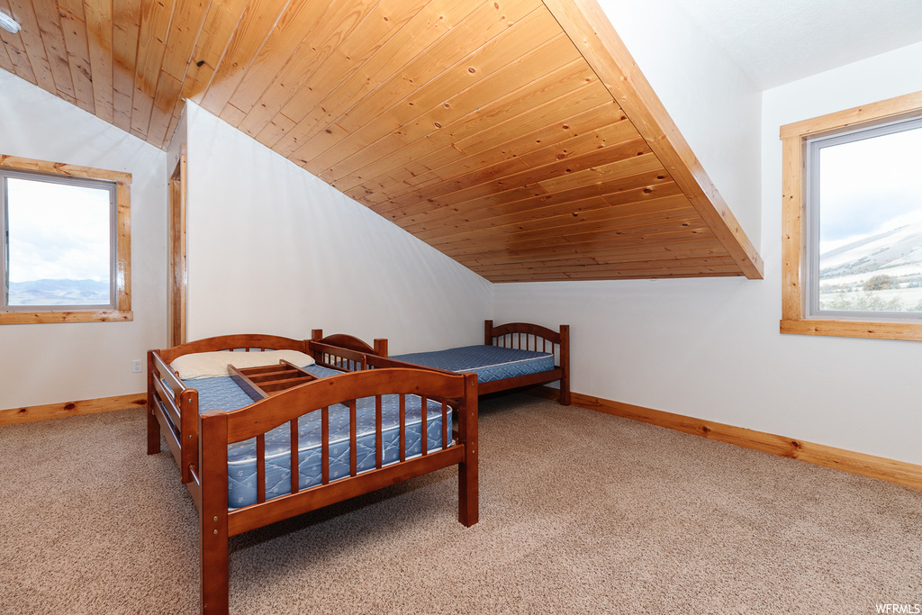 Bedroom with vaulted ceiling, carpet, and wooden ceiling