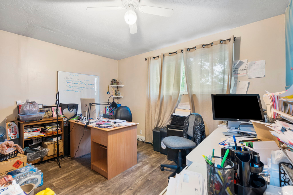 Wood floored office featuring ceiling fan