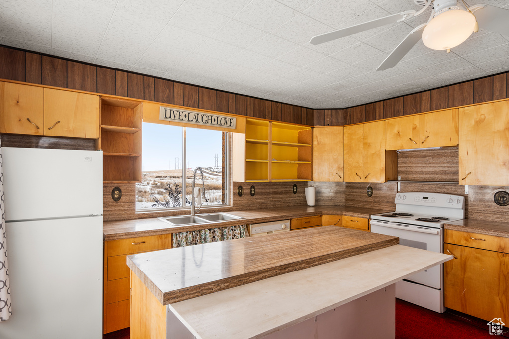Kitchen featuring sink, white appliances, backsplash, a kitchen island, and ceiling fan