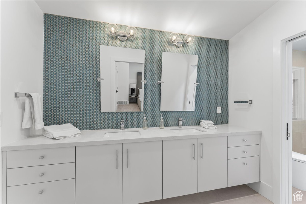 Bathroom featuring an inviting chandelier, toilet, tile floors, and dual bowl vanity