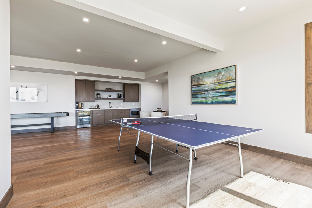 Recreation room with sink, hardwood / wood-style floors, and beverage cooler
