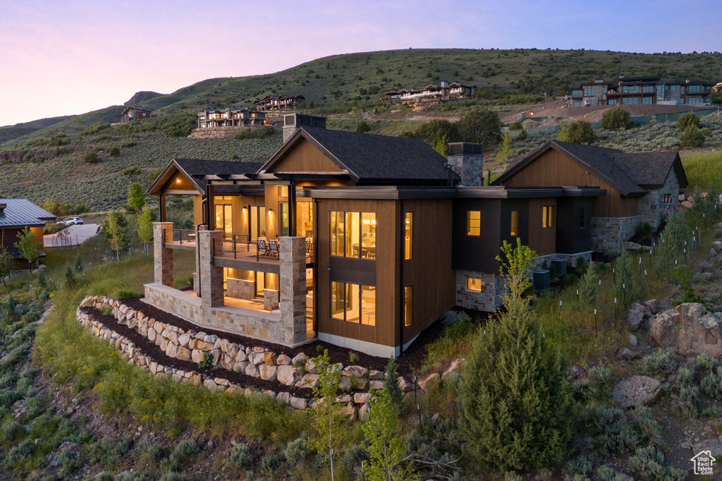 Back house at dusk with a balcony and a mountain view