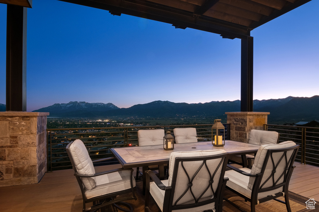 Patio terrace at dusk with a balcony and a mountain view