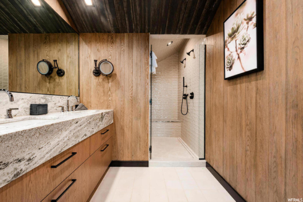 Bathroom with a tile shower, wooden walls, tile floors, wooden ceiling, and vanity