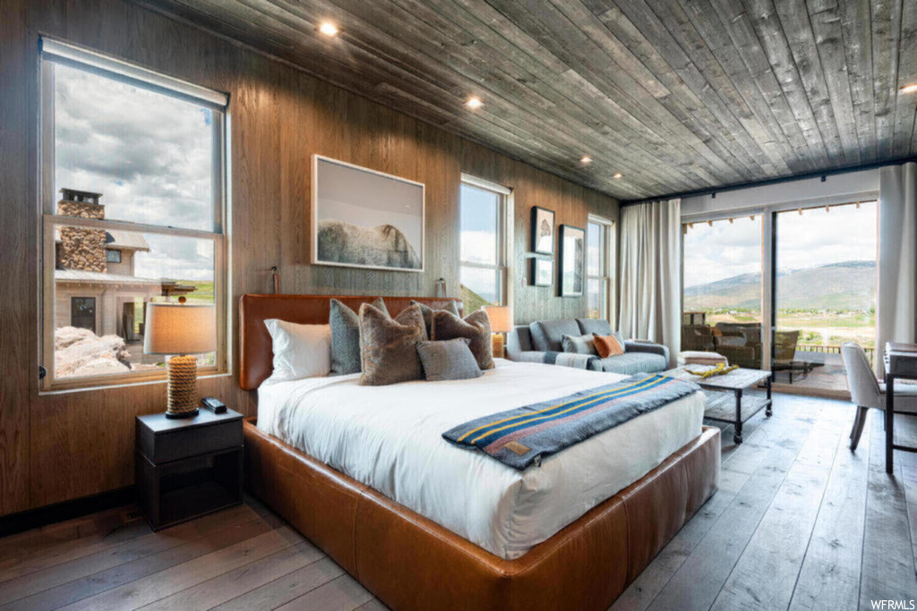 Bedroom with wood ceiling, hardwood flooring, and wood walls