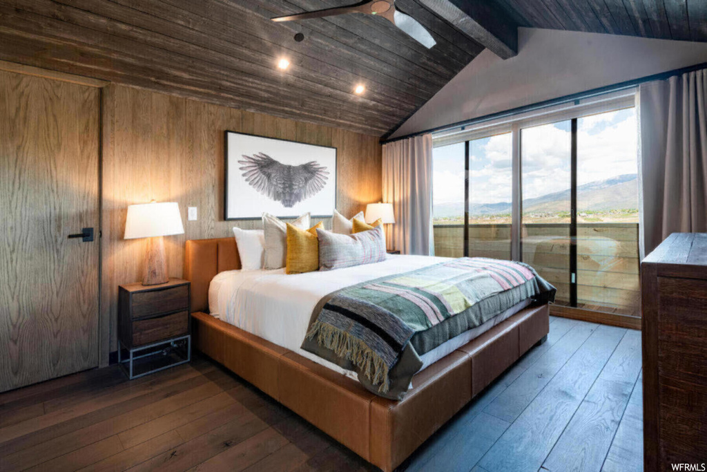 Bedroom with dark hardwood flooring, access to exterior, ceiling fan, and lofted ceiling with beams