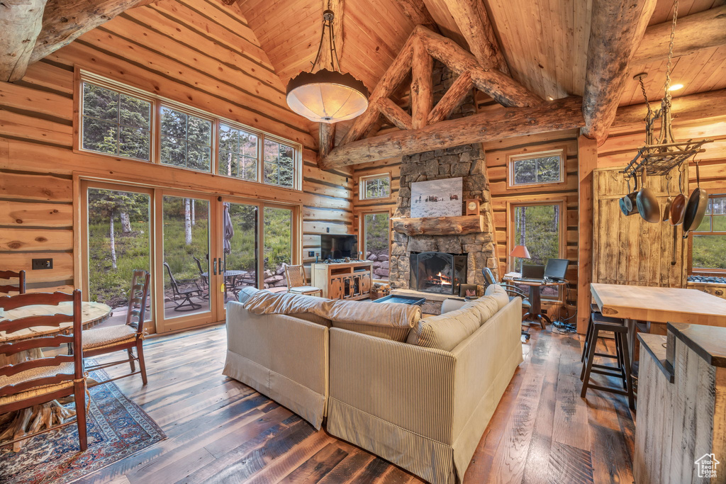 Living room with plenty of natural light, dark hardwood / wood-style flooring, wooden ceiling, and a fireplace