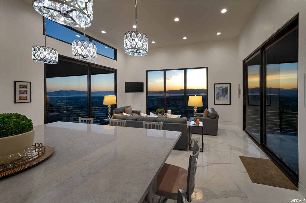 Dining area with light tile flooring, a mountain view, a towering ceiling, and a chandelier