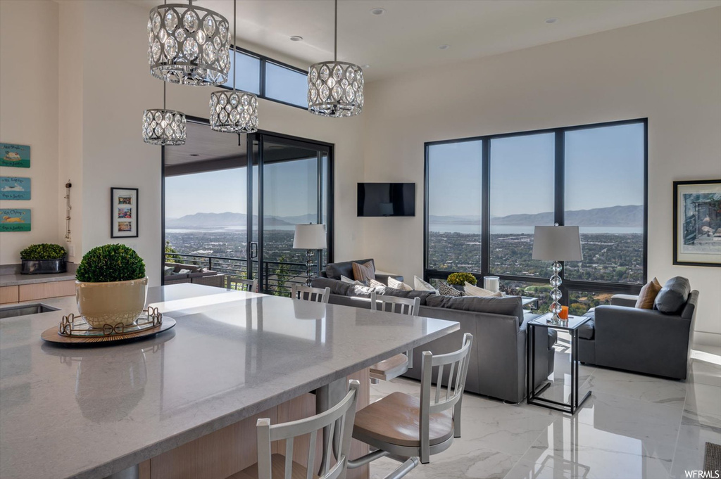 Kitchen featuring a mountain view, pendant lighting, a notable chandelier, and a healthy amount of sunlight