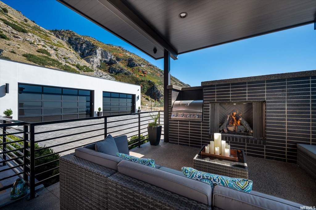 View of patio with a balcony, a mountain view, and a fireplace
