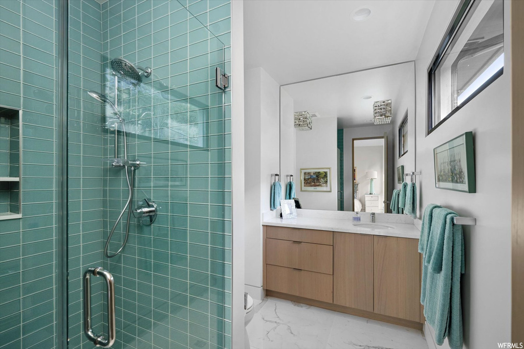 Bathroom with walk in shower, large vanity, and tile flooring