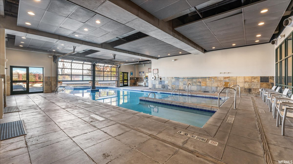 View of swimming pool featuring a patio area and an indoor hot tub