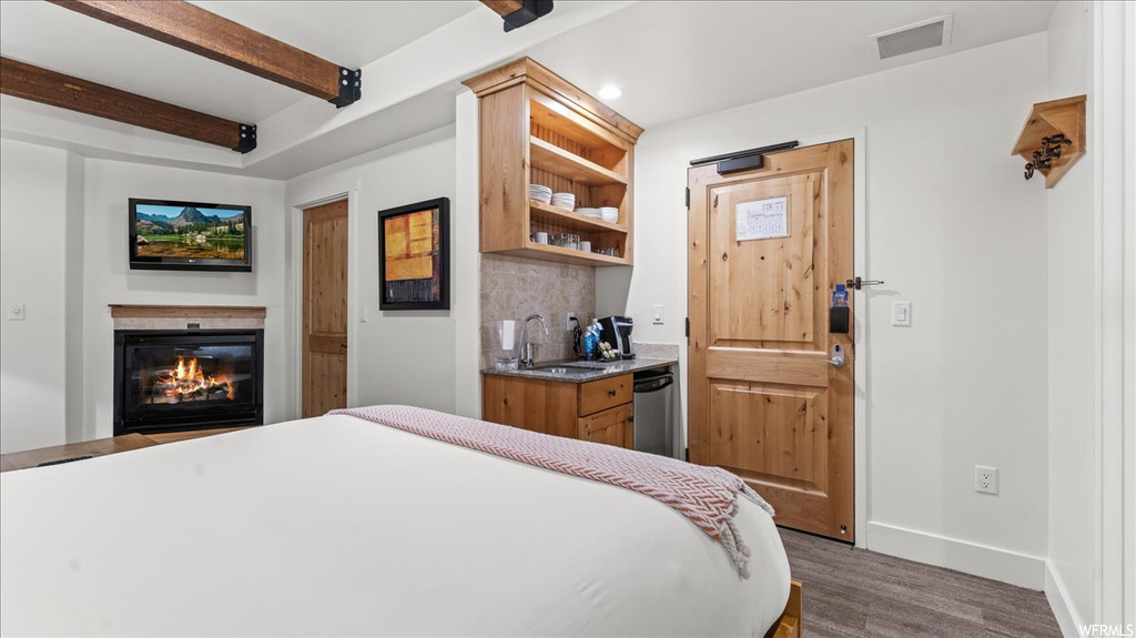 Bedroom featuring sink, dark hardwood flooring, and beamed ceiling