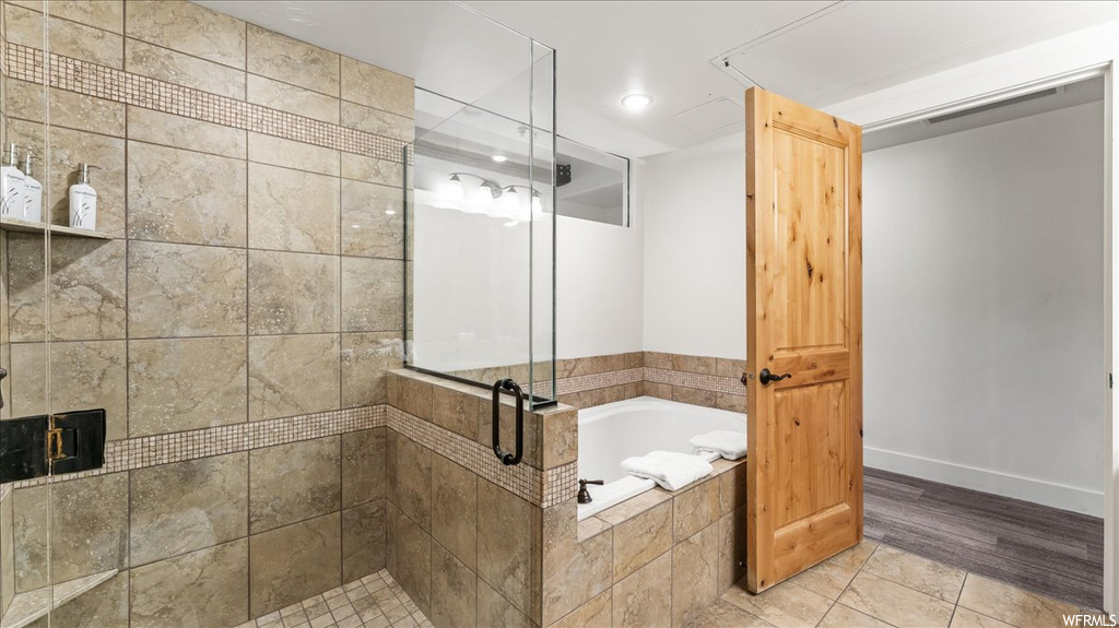Bathroom with hardwood flooring and independent shower and bath