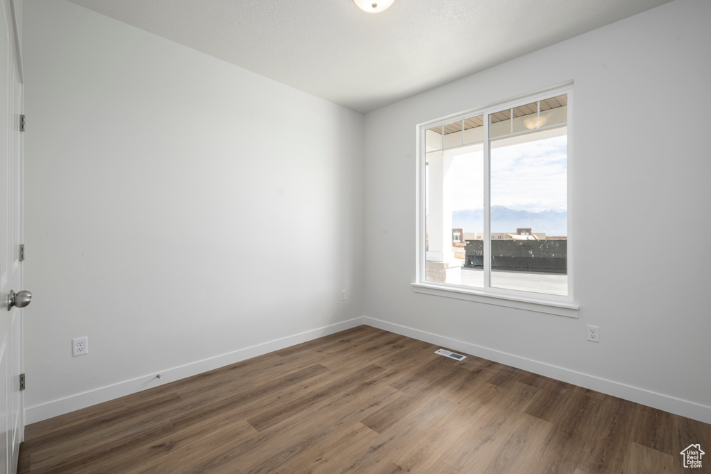 Empty room featuring dark wood-type flooring