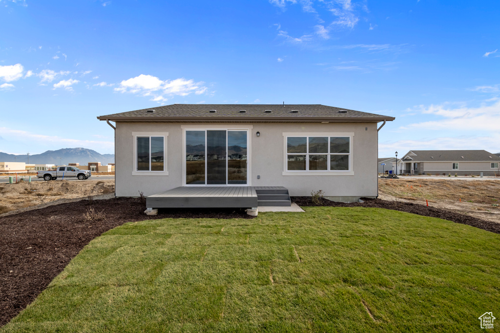 Rear view of house featuring a yard and a mountain view