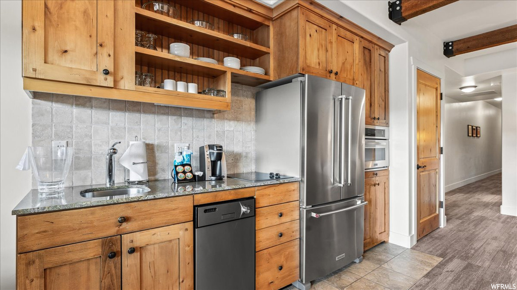 Kitchen with sink, light hardwood floors, tasteful backsplash, beam ceiling, and stainless steel appliances