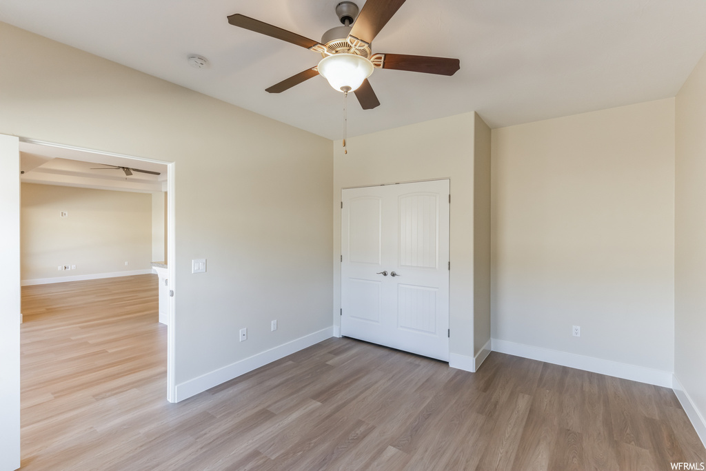 Unfurnished bedroom featuring a closet, light hardwood floors, and ceiling fan