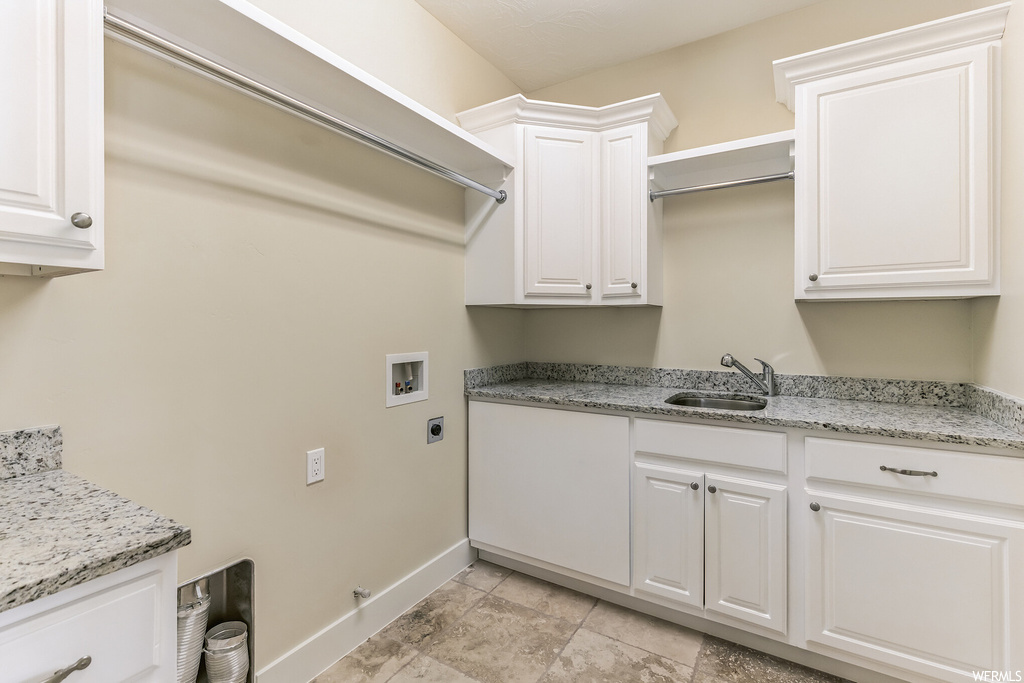 Clothes washing area featuring cabinets, washer hookup, electric dryer hookup, light tile flooring, and sink