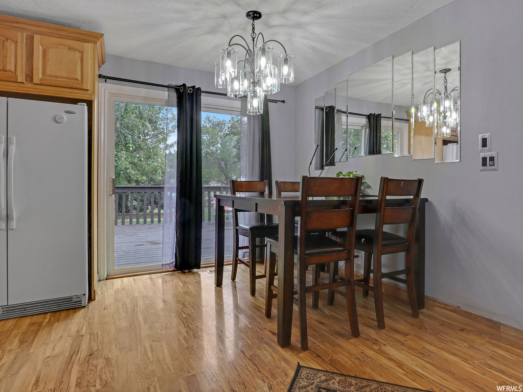 Dining space featuring plenty of natural light, an inviting chandelier, and light hardwood flooring
