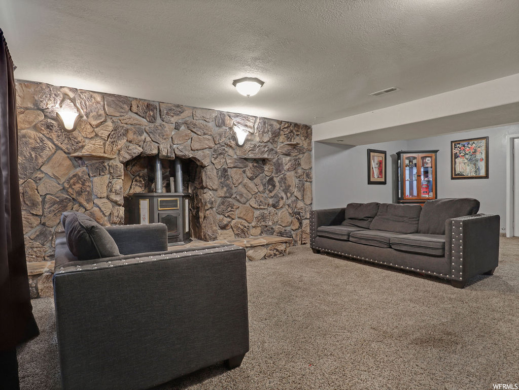 Living room with light carpet, a textured ceiling, and a fireplace