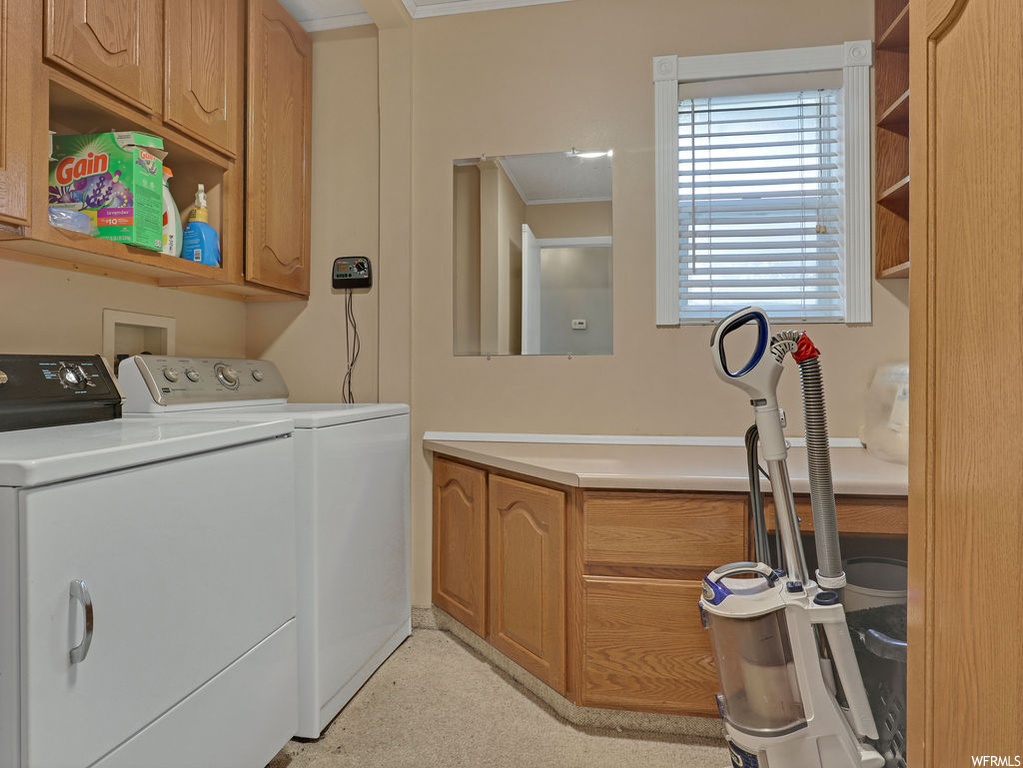 Laundry area featuring washer hookup, independent washer and dryer, cabinets, and ornamental molding
