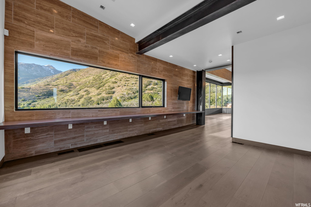 Wood floored spare room with a mountain view and beamed ceiling