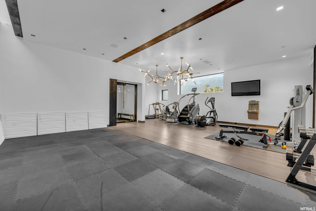 Gym featuring an inviting chandelier and hardwood floors