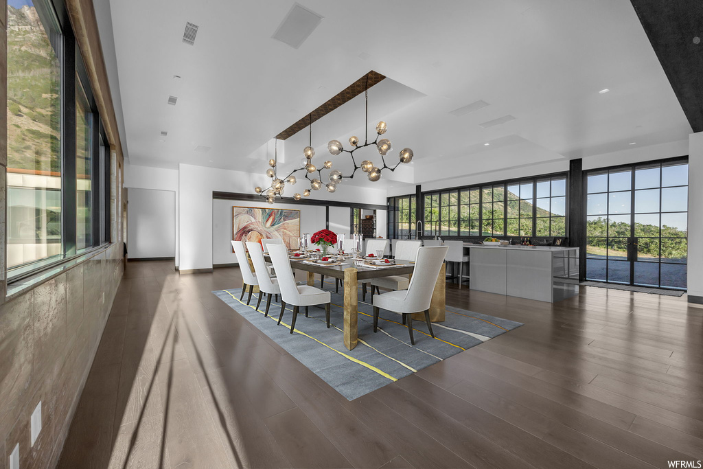 Hardwood floored dining room featuring a notable chandelier