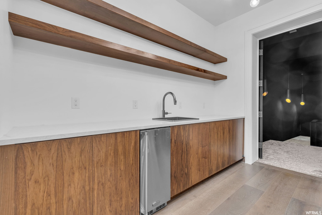 Kitchen with sink, fridge, and light hardwood floors
