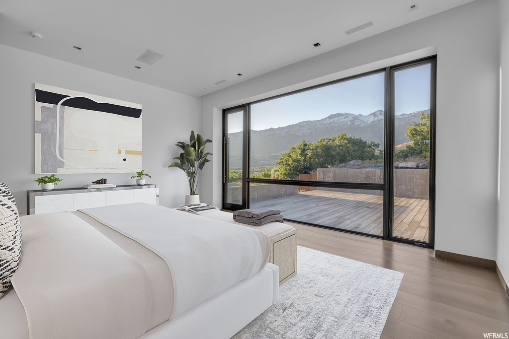 Hardwood floored bedroom featuring a mountain view and access to exterior