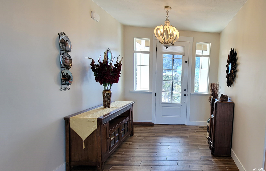 Foyer with a notable chandelier and dark hardwood floors