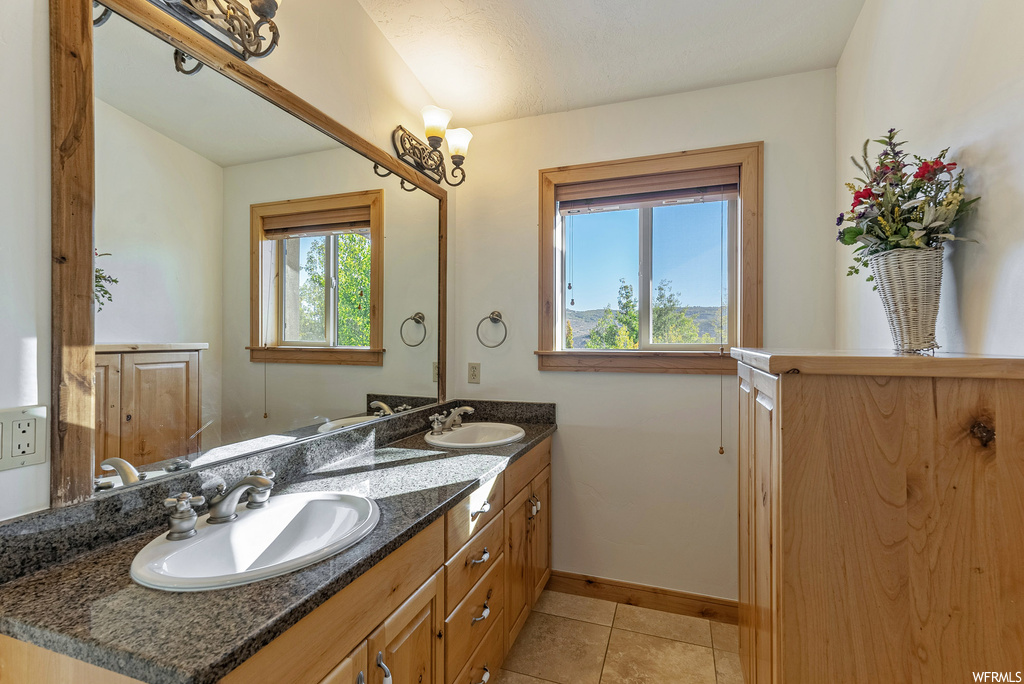 Bathroom featuring double vanity and tile flooring