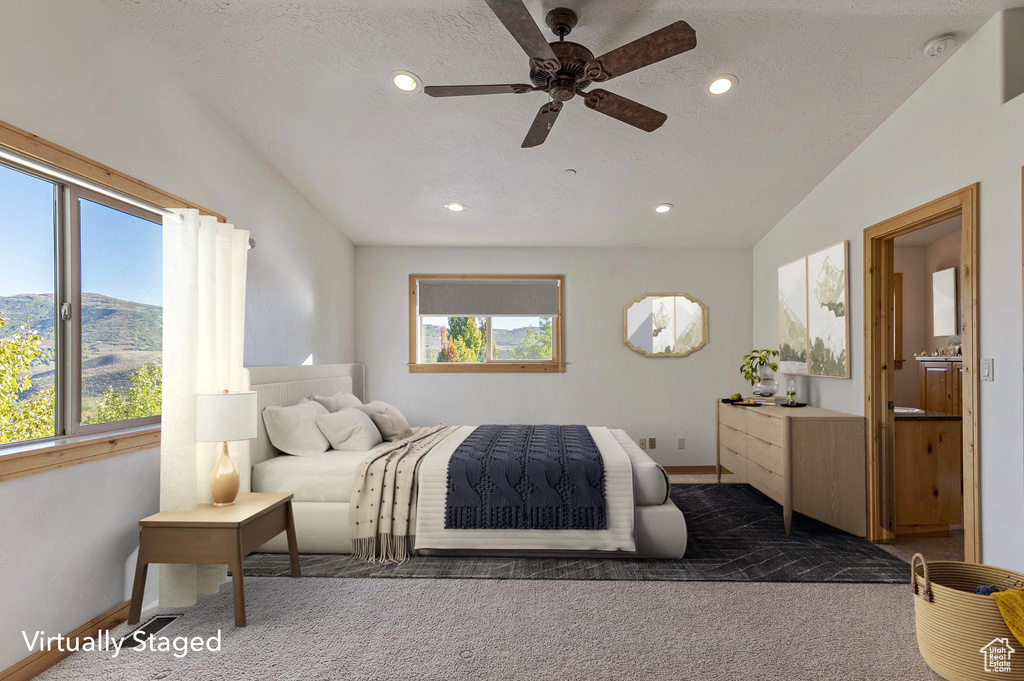 Carpeted bedroom featuring ceiling fan, multiple windows, and vaulted ceiling