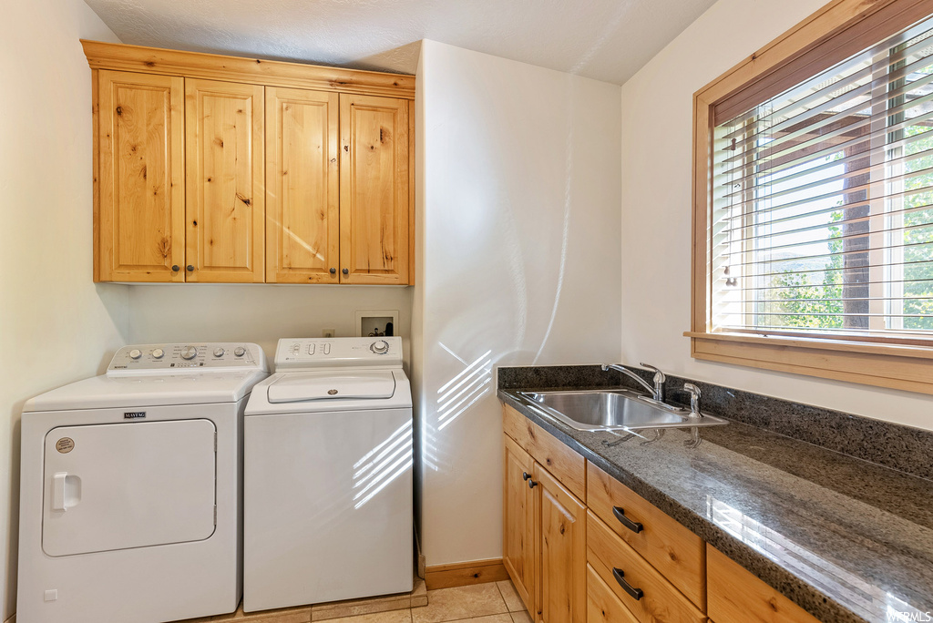 Washroom featuring independent washer and dryer, cabinets, light tile floors, hookup for a washing machine, and sink
