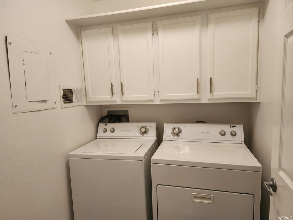 Laundry area with cabinets, separate washer and dryer, and hookup for a washing machine