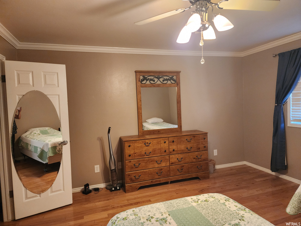 Bedroom featuring crown molding, ceiling fan, and light hardwood floors