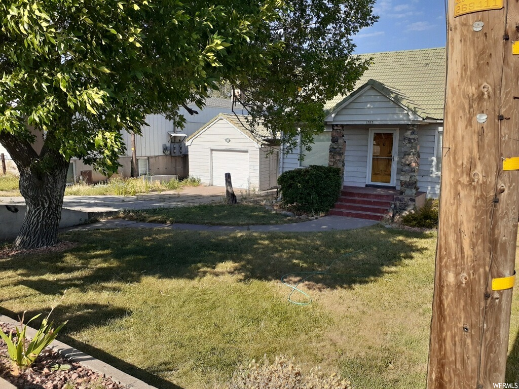 View of front facade featuring a front yard and a garage