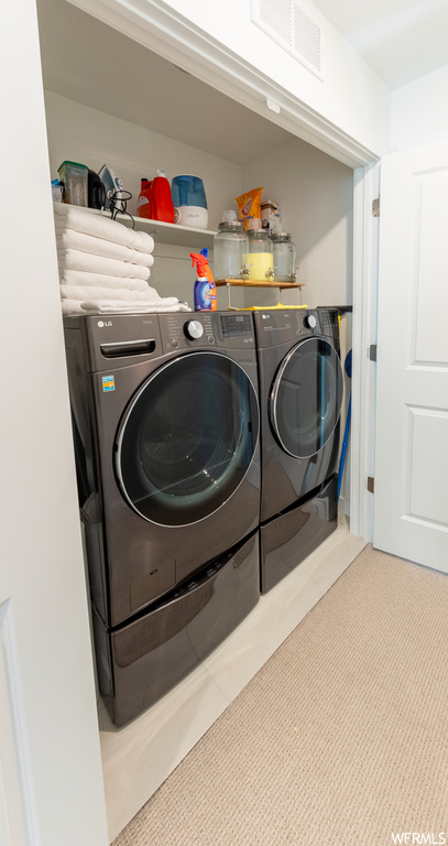 Laundry area with washing machine and dryer and light carpet