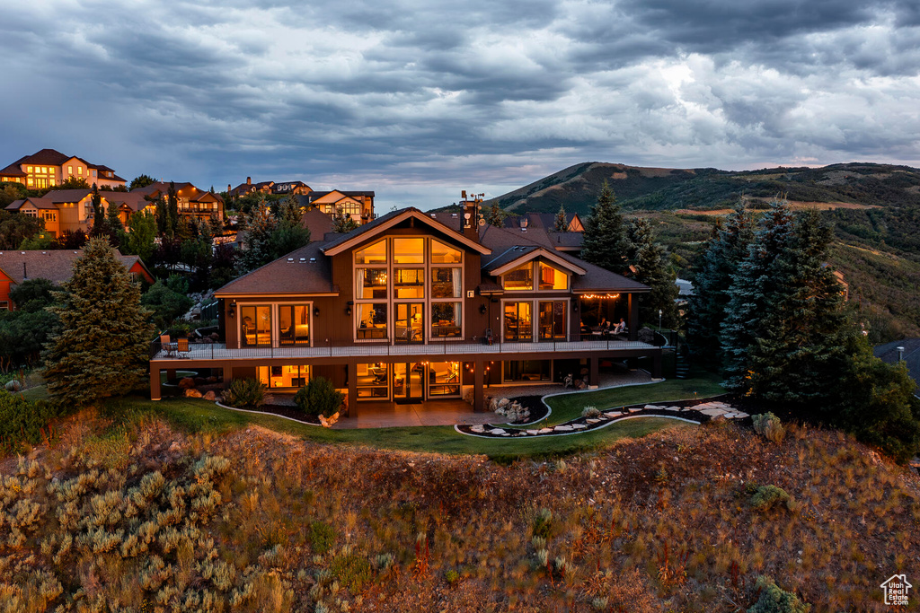 Back of house featuring a mountain view and a patio area