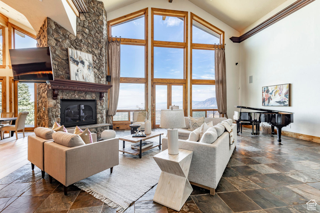 Living room with a mountain view, high vaulted ceiling, plenty of natural light, and a fireplace