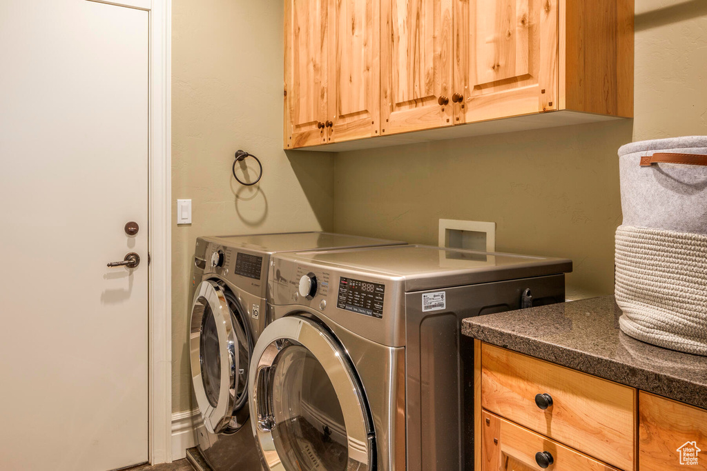 Washroom with washer and dryer and cabinets