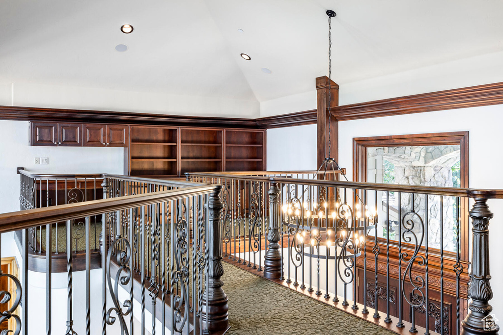 Hall with a notable chandelier, carpet flooring, and lofted ceiling