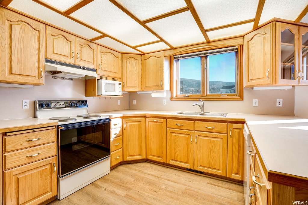 Kitchen featuring white appliances, sink, and light hardwood flooring
